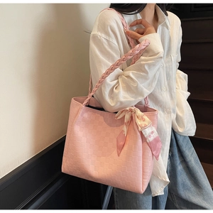 Detail van roze geweven shopper met gevlochten handvatten en zijden sjaal met kersenpatroon