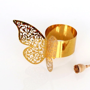 Détail du rond de serviette papillon doré avec motif ajouré complexe pour mariages