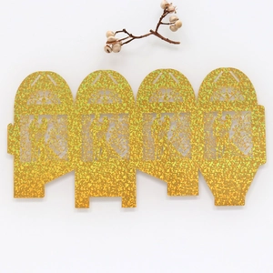Flat lay of laser-cut gold glitter wedding favor box with Mr & Mrs silhouette design