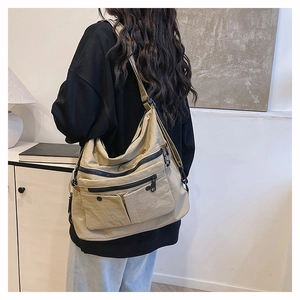 Detail of khaki water-resistant nylon tote with multiple utility pockets and adjustable strap
