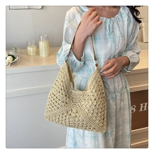 Detail of hollow crochet knit tote bag with brown leather shoulder strap for summer beach