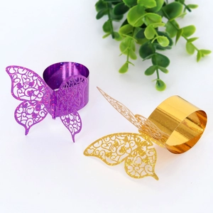 Detail of purple and gold hollow butterfly napkin rings with laser-cut heart patterns