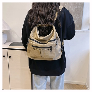 Khaki multi-pocket canvas tote bag worn as a backpack showing utility style and storage