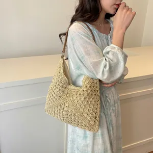 Close-up detail of cream woven tote bag with hollow crochet pattern and leather strap