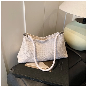 Vue détaillée du sac cabas tissé couleur crème avec détails en métal argenté