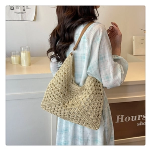 Detail of hand-woven cream tote bag with crochet hollow pattern and brown leather strap