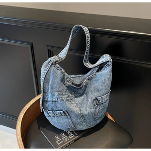Detail of vintage blue denim tote bag with stitching and pocket design on black chair