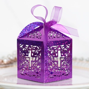 Close-up of purple glitter gift box with laser-cut cross design and silk ribbon