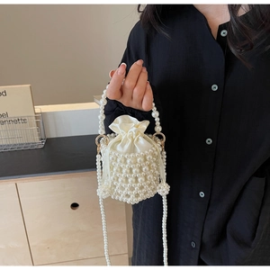 Detailed view of handmade pearl woven bucket bag with silk drawstring lining and handle