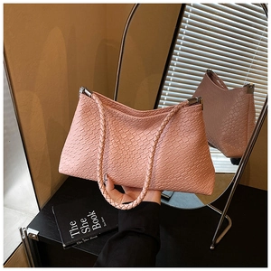 Détail de la texture en cuir tressé rose et boucle en métal argenté du sac hobo chic
