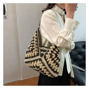Detail of the black and white geometric hand-woven pattern on a large knit tote bag