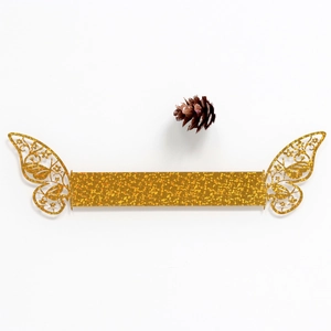 Detailed close-up of golden glitter butterfly napkin ring with laser-cut hollow patterns