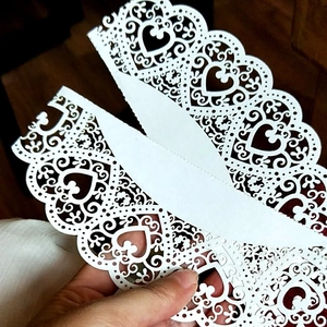 White laser cut lace paper wraps with heart and floral patterns for cupcake decoration