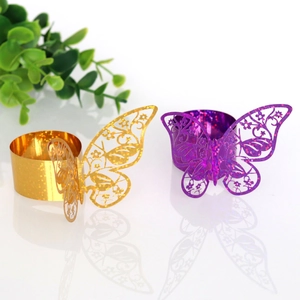 Macro detail of laser-cut butterfly napkin rings in gold and purple with glitter