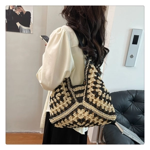 Detail of hand-woven geometric knit pattern and shoulder strap on a large tote bag