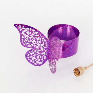 Vue macro du rond de serviette papillon violet scintillant avec motif évidé au laser