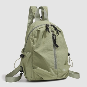 Détail d'un sac à dos en nylon vert clair imperméable avec fermeture éclair et poche latérale