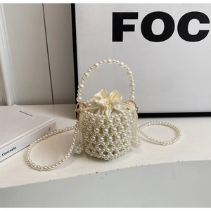 Detail of woven pearl bucket bag with satin drawstring liner and gold metal rings