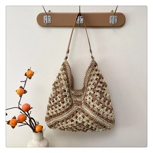 Detail of hand-crocheted geometric hollow pattern on a brown and white tote bag