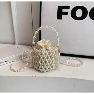 Detail of hand-woven pearl bucket bag with cream satin drawstring lining and strap