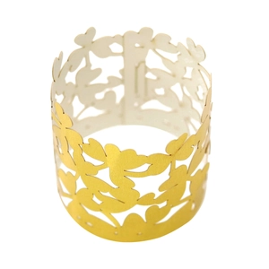 Macro view of gold clover hollow napkin ring with intricate leaf pattern laser cut texture
