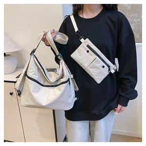 Detail view of off-white tote bag and matching chest pouch with wrinkled nylon texture