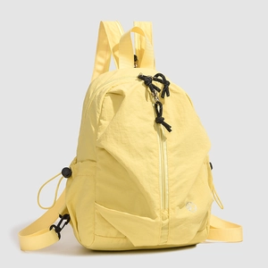 Vue détaillée du sac à dos en nylon jaune avec fermeture éclair asymétrique et cordon