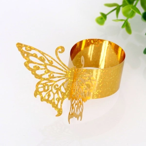 Detail of golden butterfly napkin ring with hollow floral patterns and glitter finish