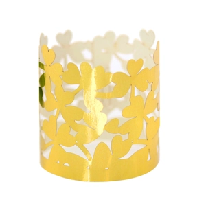 Close-up of golden hollow clover napkin rings made of pearlescent paper for party decor