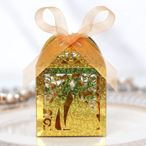 Close-up of golden laser-cut wedding candy box with glitter paper and ribbon bow
