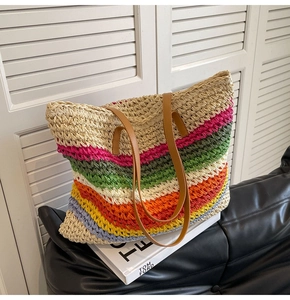 Detail of colorful rainbow woven straw tote bag with brown faux leather shoulder straps