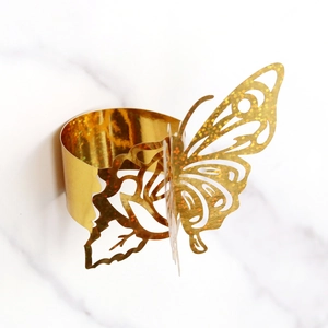 Macro detail of laser-cut butterfly napkin ring with sparkling golden glitter finish