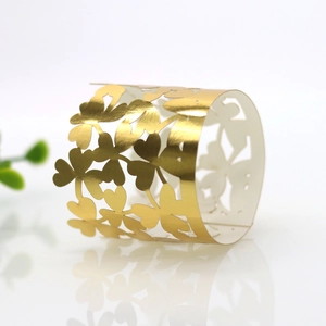 Detailed view of gold clover laser-cut paper napkin ring with mirror finish