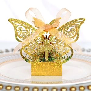 Laser-cut butterfly candy box with gold glitter finish and silk ribbon on elegant plate