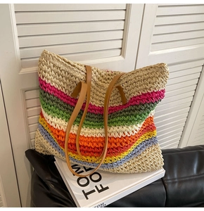 Detailed view of woven straw tote bag texture and colorful rainbow stripes detail