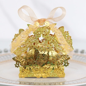 Detail of laser-cut gold butterfly gift box with glitter texture and champagne ribbon