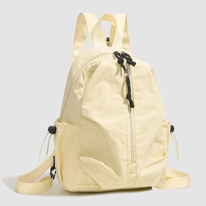 Détail du sac à dos en nylon jaune avec poches zippées et bretelles réglables