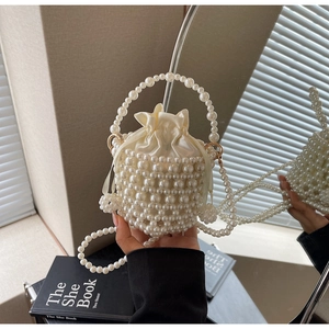 Detailed view of woven pearl bucket bag with satin drawstring liner and beaded handle