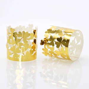 Close-up of golden hollow clover napkin rings made of shimmering pearlescent paper