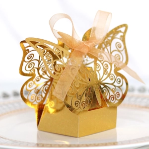 Close-up of golden laser-cut butterfly gift box with elegant ribbon and glitter finish