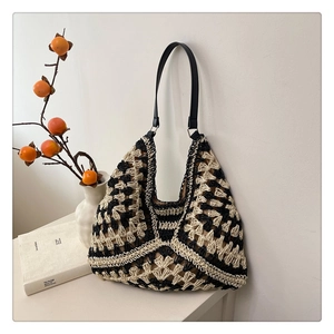 Detail of hobo tote showing geometric hollow crochet knit texture and leather strap