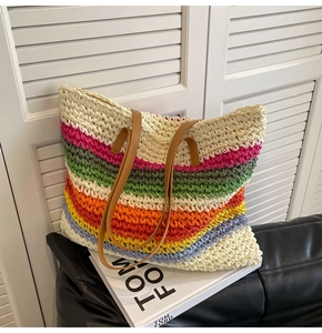 Detail of multi-color rainbow woven tote with brown leather handles and tight paper rope texture