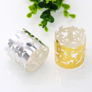 Macro shot of laser-cut clover napkin rings in gold and silver pearl paper