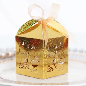Close-up of golden laser-cut 'It's a boy' gift box with sparkling glitter and ribbon