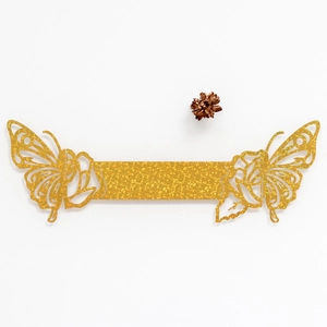 Detail of laser-cut butterfly napkin ring with golden glitter surface for weddings