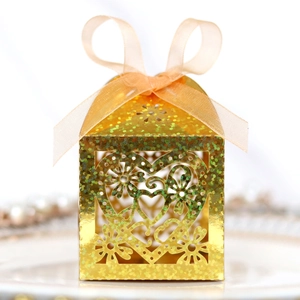 Golden laser cut heart favor box with glitter finish and elegant peach silk ribbon bow