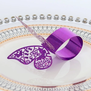 Détail d'un rond de serviette papillon violet découpé au laser avec finition pailletée