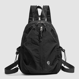 Vue de face du sac à dos noir en nylon avec poches multiples et logo rond blanc