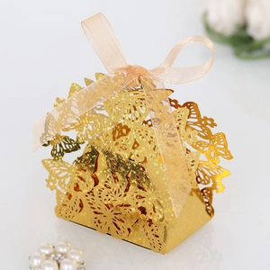 Detail of golden laser-cut butterfly gift box with elegant champagne ribbon bow