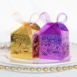 Detailed laser-cut candy boxes with It's A boy text and glitter finish on a white tray